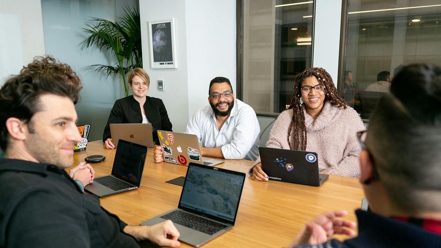 A team sitting with laptops around a meeting table